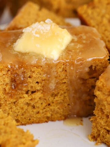 Slice of pumpkin cornbread topped with butter and honey.