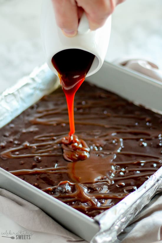 Caramel being drizzled on a pan of brownies.