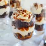 Brownie trifles in a glass dish topped with caramel.