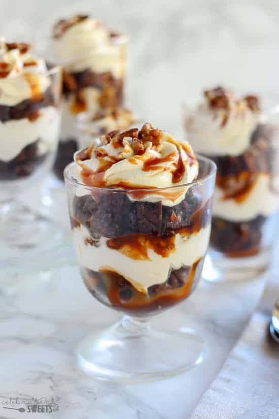 Brownie trifles in a glass dish topped with caramel.
