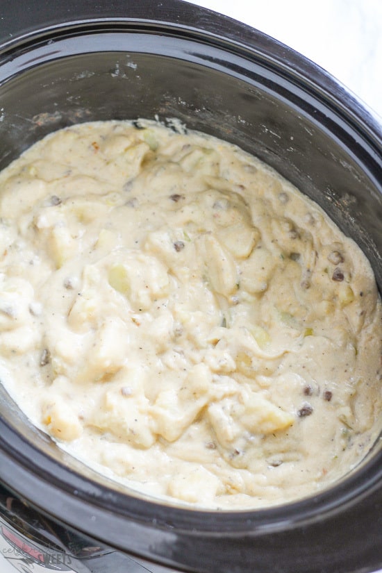 Creamy potatoes in a black slow cooker.