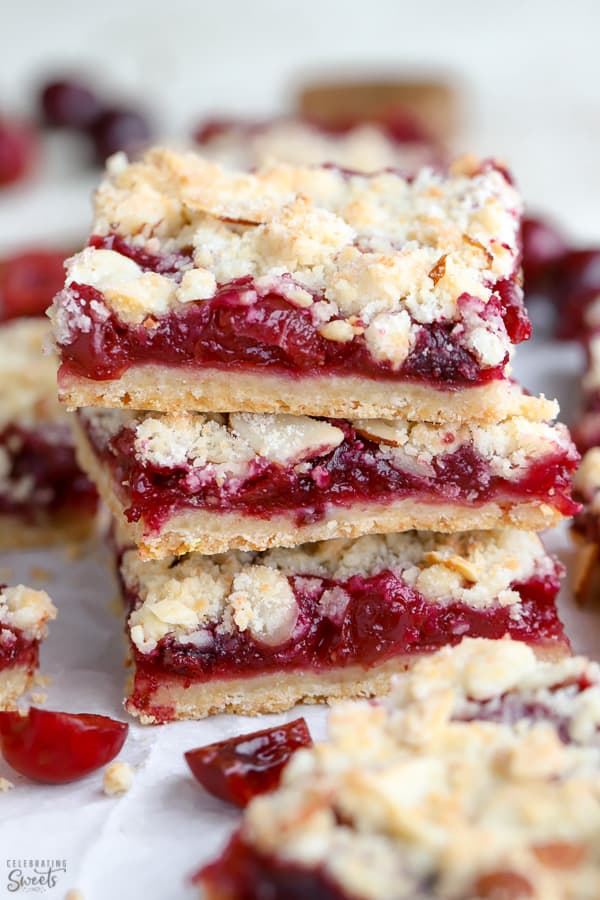 Pile de trois barres de crumble aux amandes remplies de cerises.