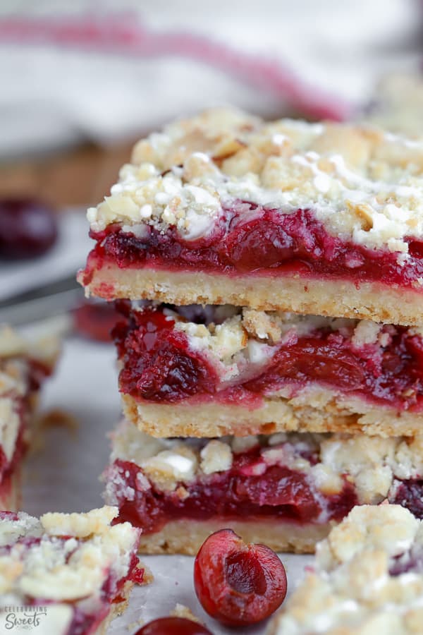 Stack of three almond crumble bars filled with cherries.