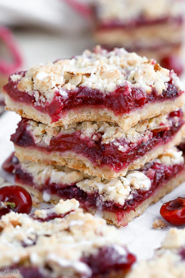 Stack of three almond crumble bars filled with cherries.