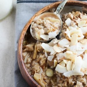 Bowl of oatmeal topped with coconut and almonds.