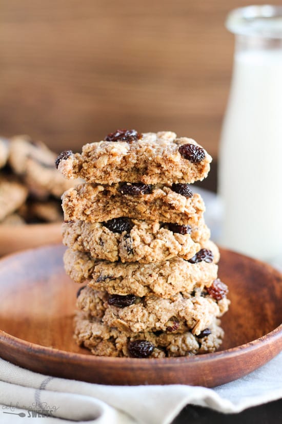 Stack of oatmeal raisin cookies on a wooden plate.