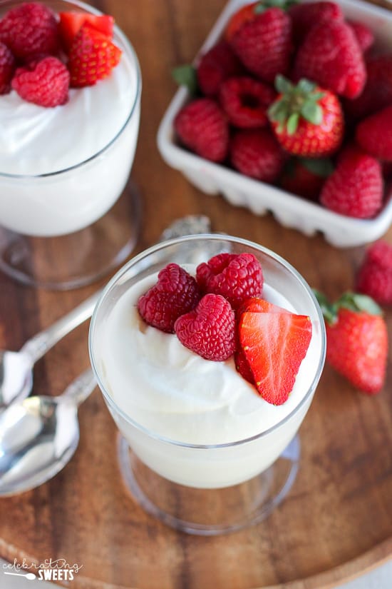 Glass dish filled with white mousse and berries. 