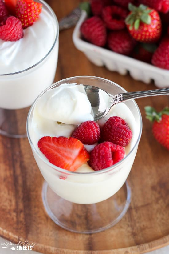 Glass dish filled with white mousse and berries. 