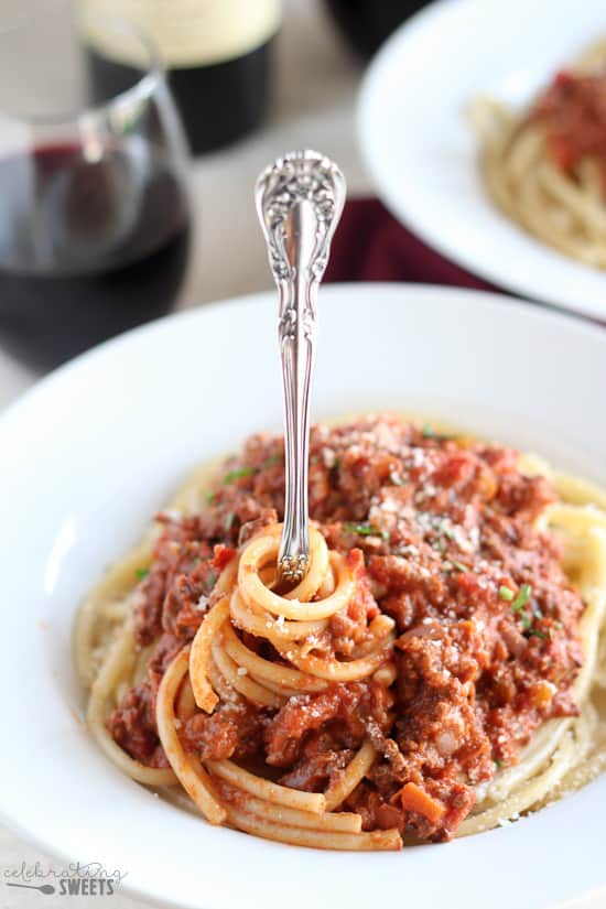 Bowl of pasta topped with meat sauce and a fork.