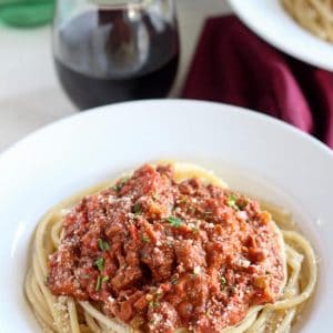 Bowl of pasta topped with meat sauce.