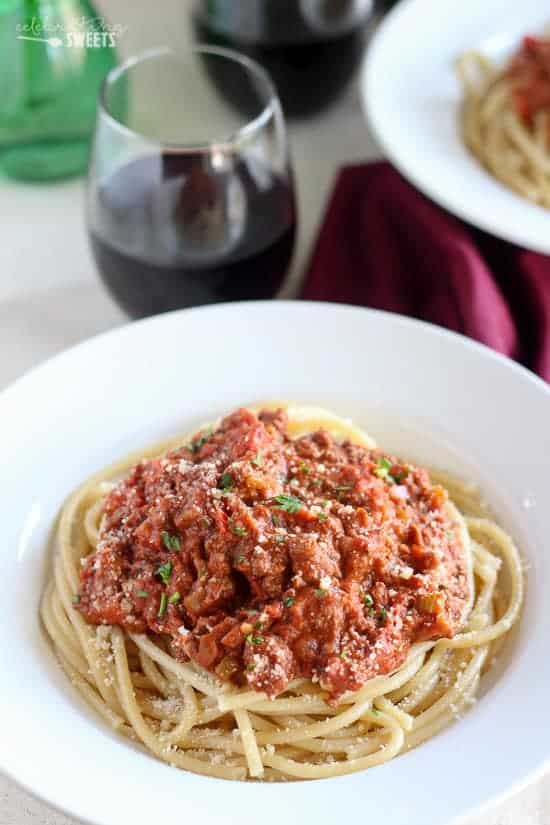 Bowl of pasta topped with meat sauce.