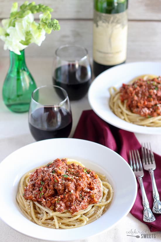 Bowl of pasta topped with meat sauce.