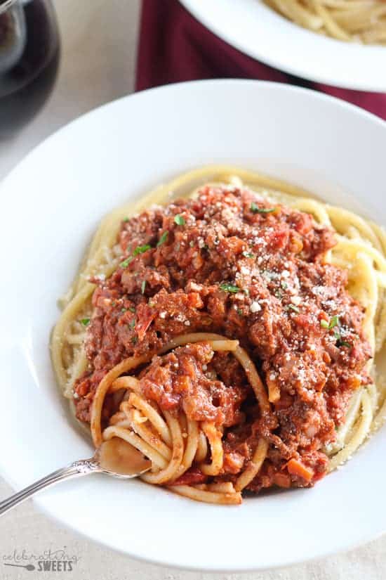 Bowl of pasta topped with meat sauce.
