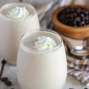 Coffee smoothie in a glass topped with whipped cream.
