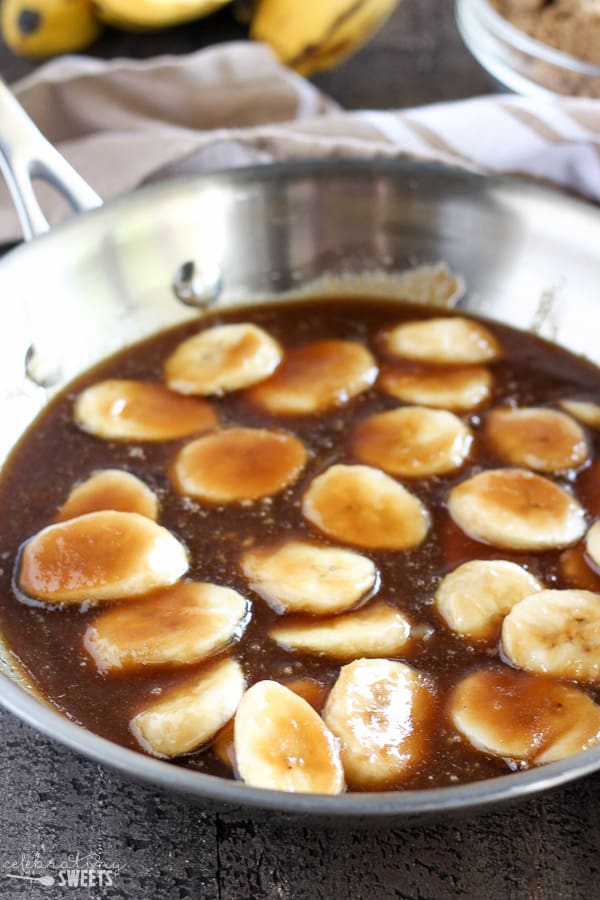 Sliced banana in a pan with brown sugar sauce.