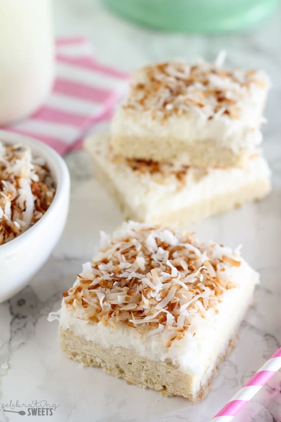 Stack of sugar cookie bars topped with coconut.