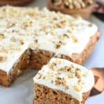 Square slice of carrot cake topped with white frosting.