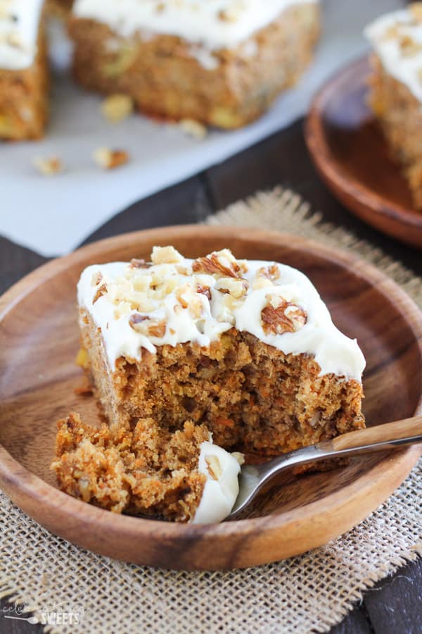 Slice of carrot cake on a wooden plate.