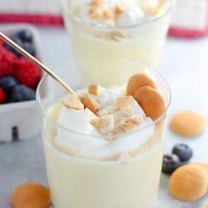 Vanilla pudding in a glass with vanilla wafer cookies.