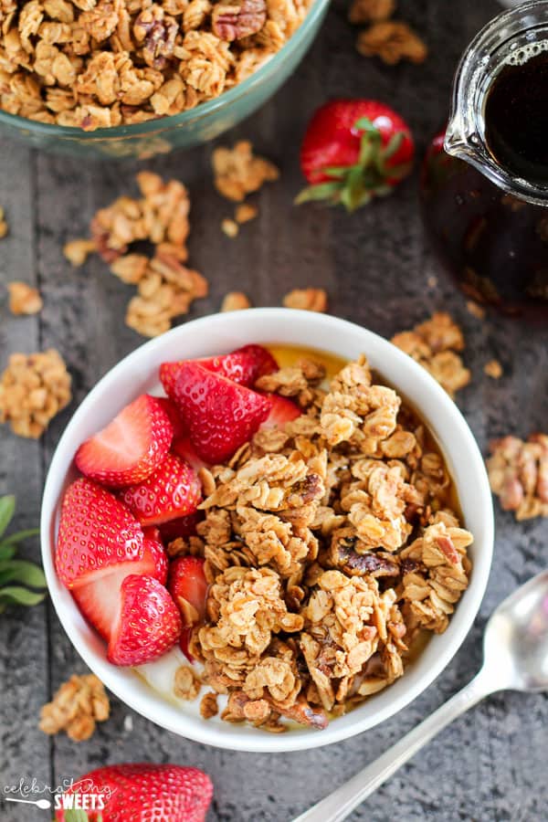 White bowl with granola, yogurt and strawberries. 