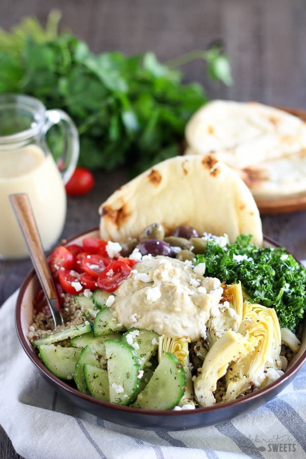 Quinoa bowls topped with vegetables and hummus.