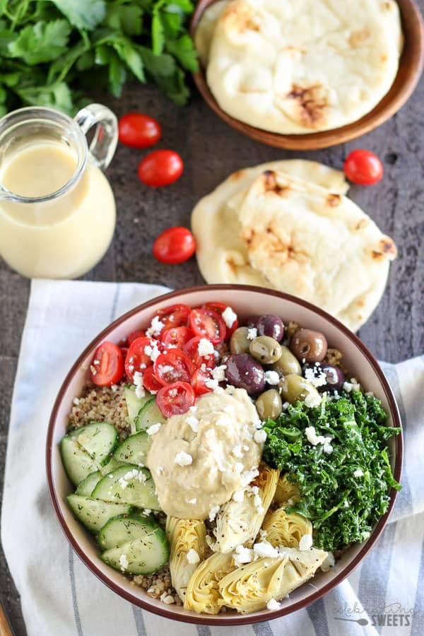 Quinoa bowls topped with vegetables and hummus.