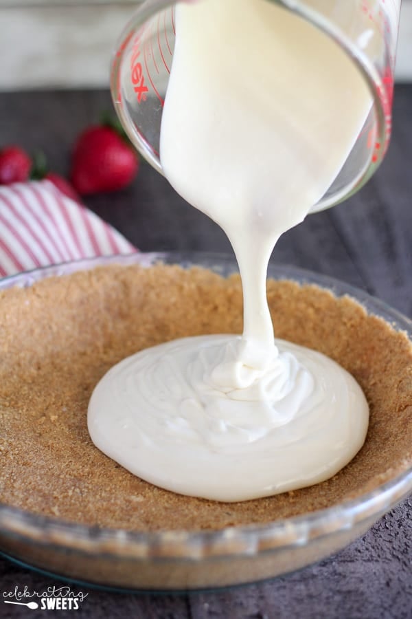 Cream cheese filling being poured into a pie crust.