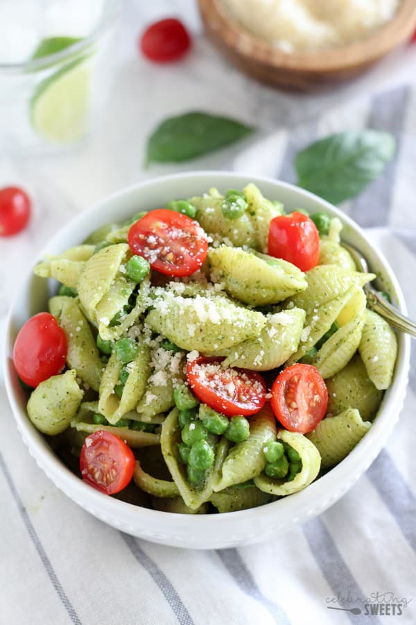 Bowl of pasta shells with pesto and peas.