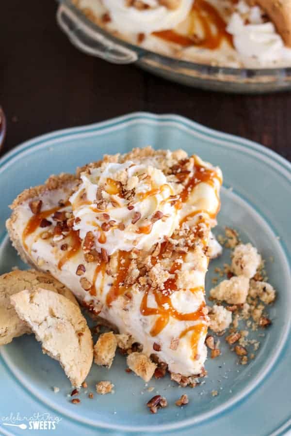 Slice of ice cream pie topped with caramel sauce and cookies.