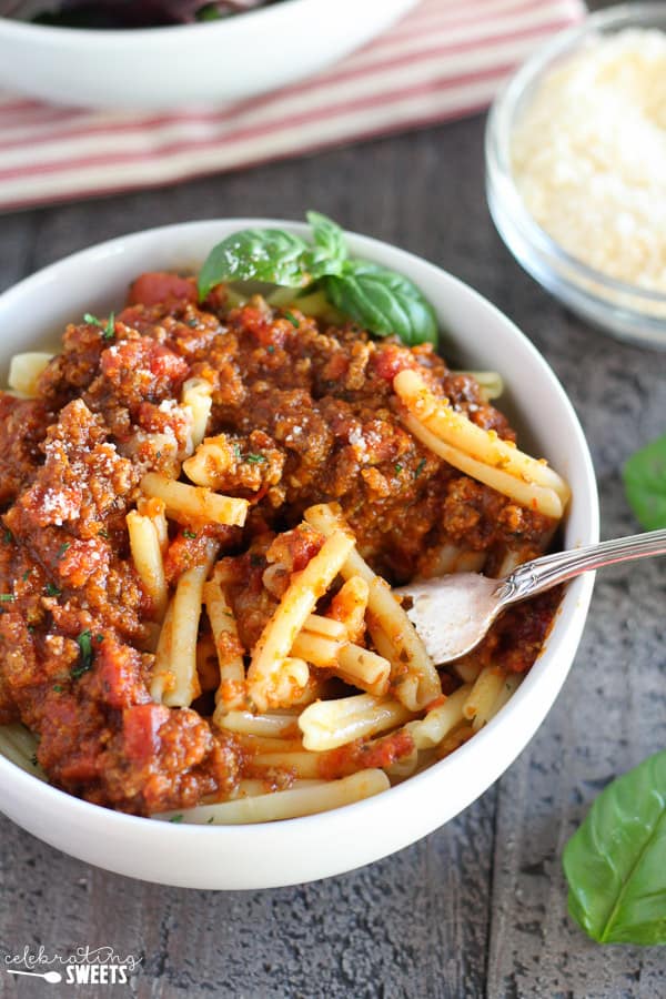 Bowl of pasta topped with meat sauce. 