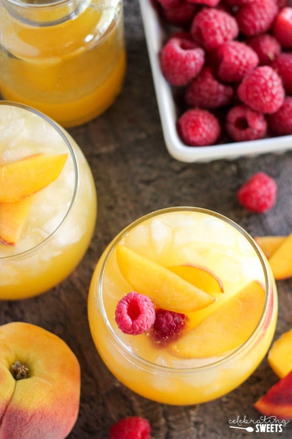 Peach margarita garnished with peaches and raspberries.