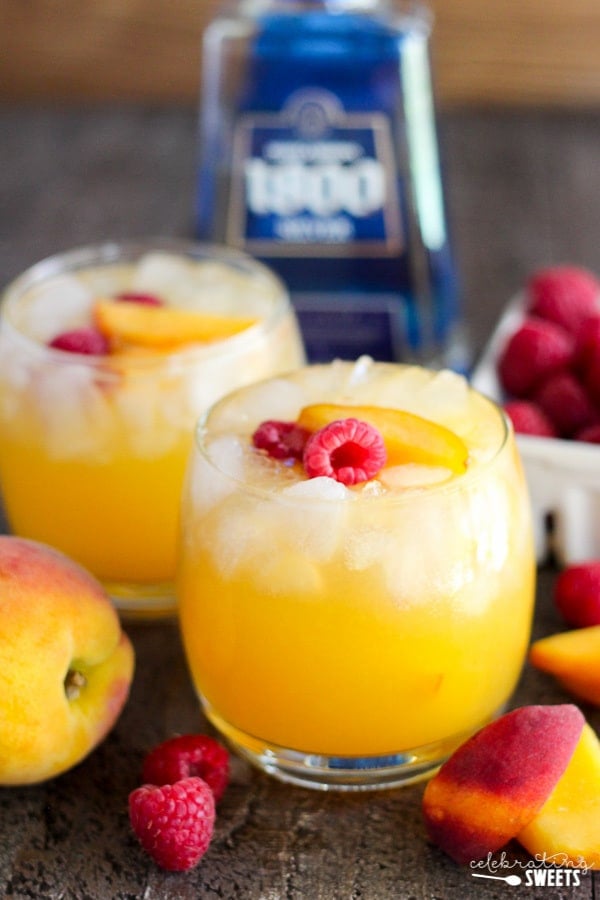 Peach margarita garnished with peaches and raspberries.