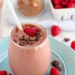 Chocolate smoothie topped with raspberries.