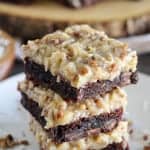 Stack of brownies with coconut frosting.