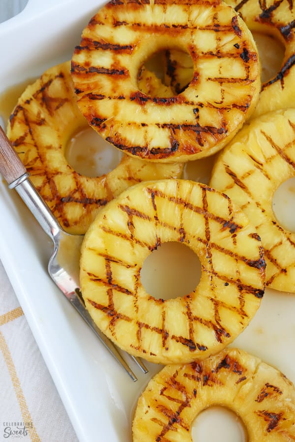 Grilled pineapple slices on a white plate.
