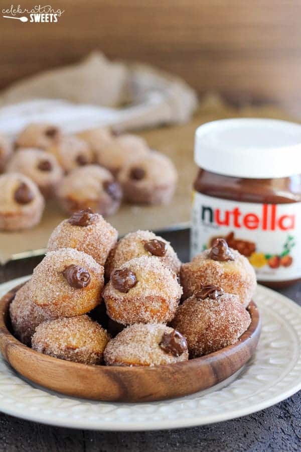 Bowl of donut holes filled with chocolate sauce coated in sugar.
