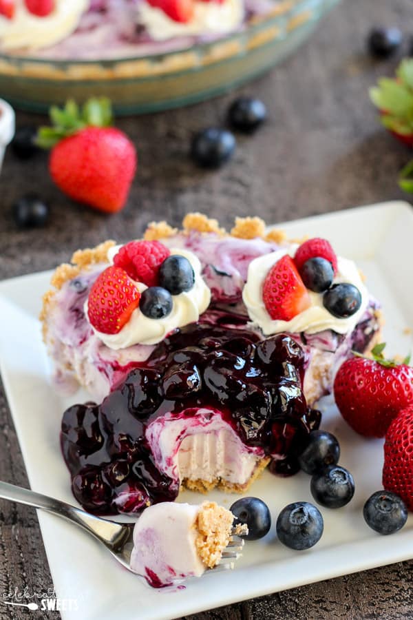 Slice of berry ice cream pie topped with blueberry sauce. 