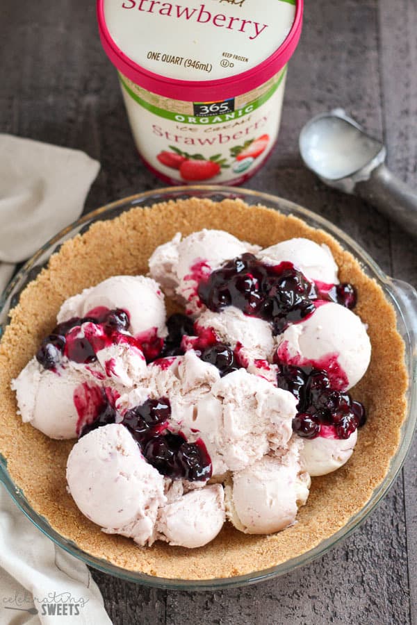 Scoops of ice cream and blueberry sauce in a graham cracker crust.