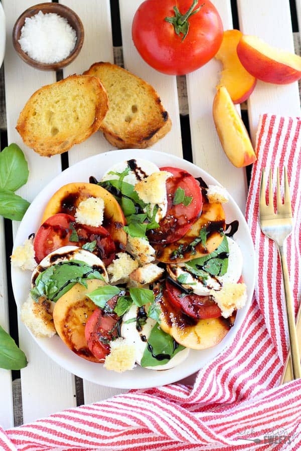 Sliced peaches, tomato, and mozzarella topped with basil and balsamic vinegar.