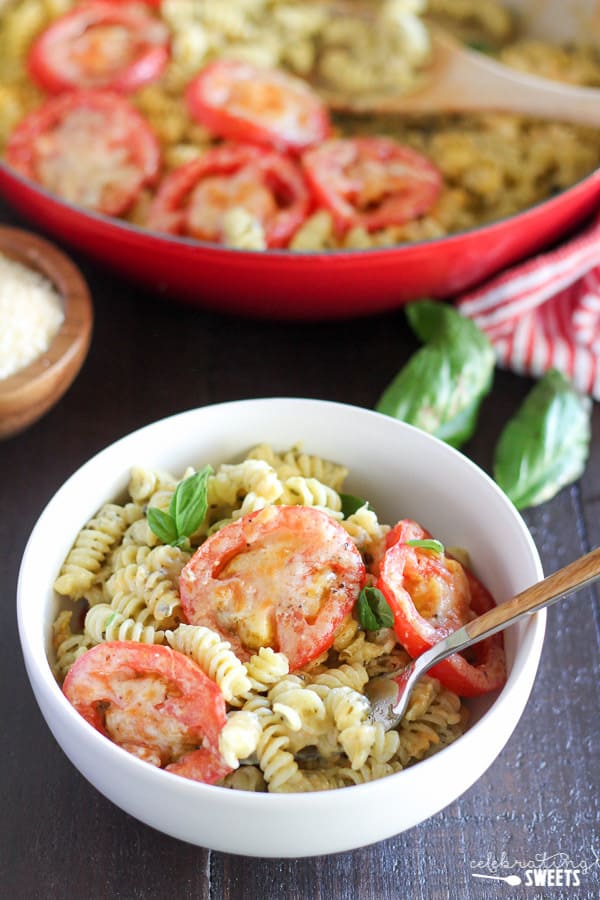 A close up of macaroni and cheese topped with sliced tomatoes. 