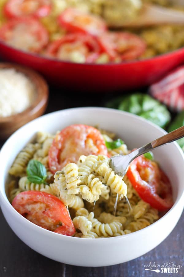 A close up of macaroni and cheese topped with sliced tomatoes. 