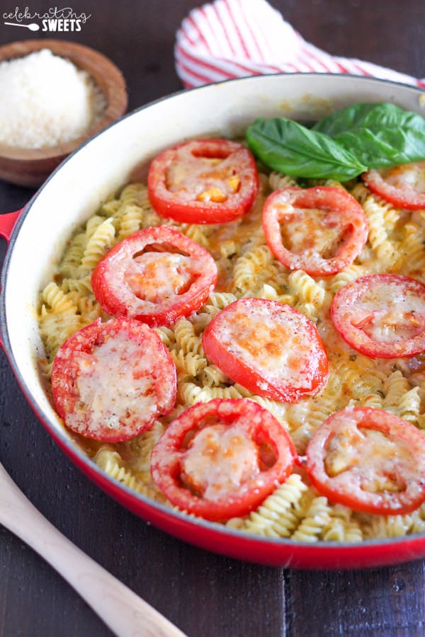 A close up of macaroni and cheese topped with sliced tomatoes. 