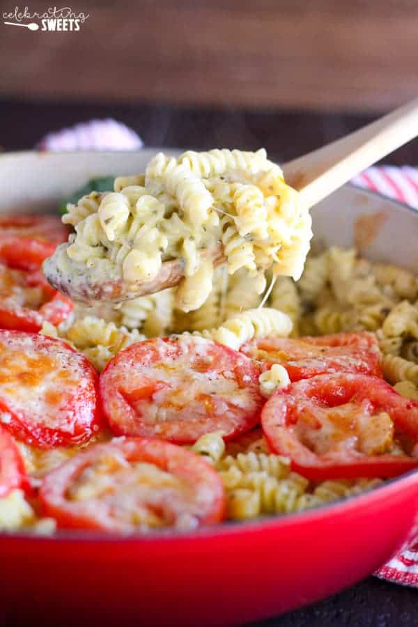 A close up of macaroni and cheese topped with sliced tomatoes. 