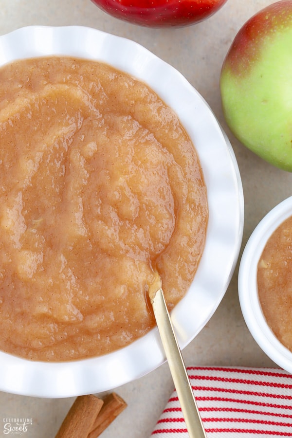 Applesauce in a white bowl with a gold spoon