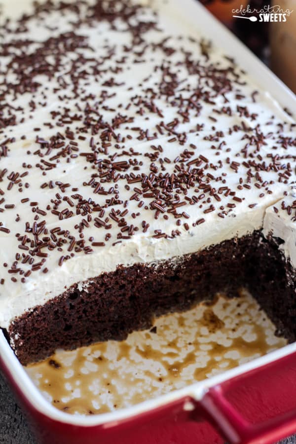 Chocolate cake in a casserole dish topped with whipped cream and chocolate sprinkles. 