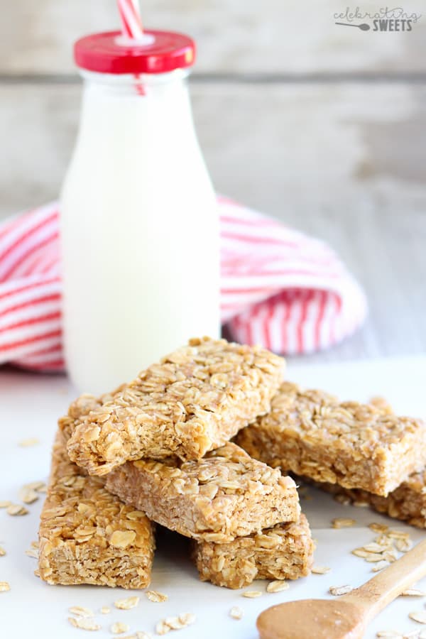 Peanut butter granola bars with milk in the background. 