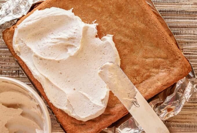 Frosting being spread on a chai cookie bar.