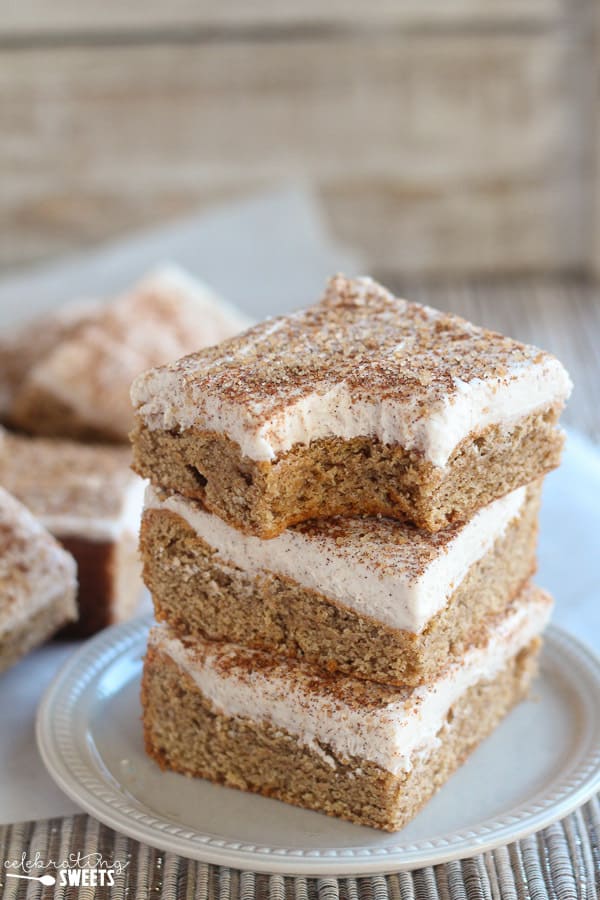 Stack of cookie bars topped with frosting and cinnamon sugar.