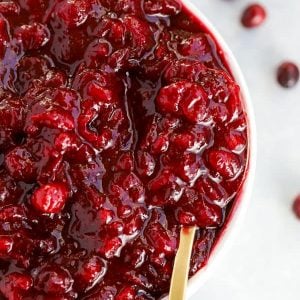 Bowl of cranberry sauce with a gold spoon.