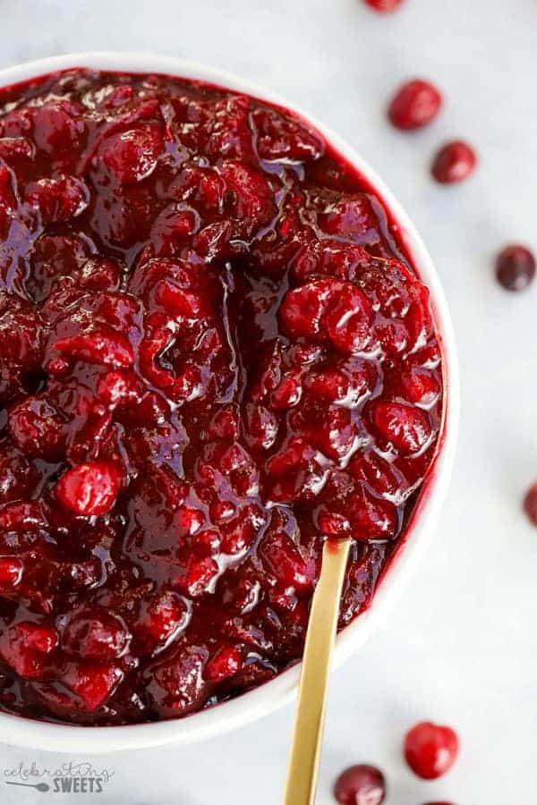 Bowl of cranberry sauce with a gold spoon.